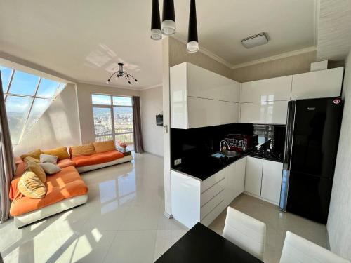 a living room with an orange couch and a kitchen at Graz Narek house in Altenfelden