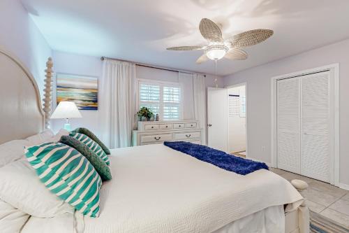 a bedroom with a white bed and a ceiling fan at Always an Optimist in Pensacola