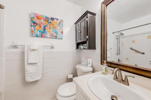 La salle de bains est pourvue d'un lavabo, de toilettes et d'un miroir. dans l'établissement Always an Optimist, à Pensacola