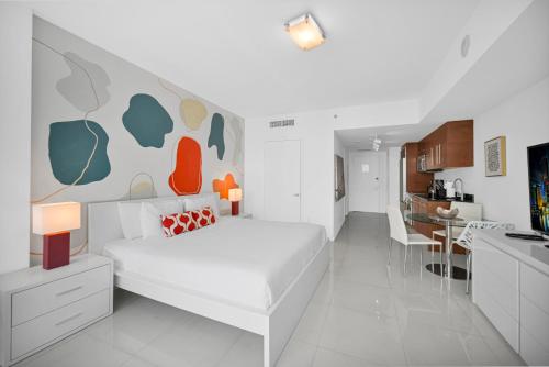 a bedroom with a white bed and a kitchen at Stylish Studio Icon, W Hotel Waterfront Building in Miami