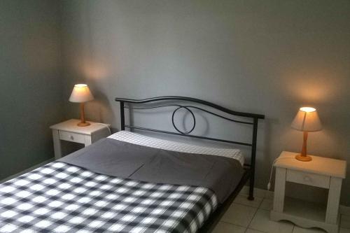 ein Schlafzimmer mit einem Bett und zwei Tischen mit Lampen in der Unterkunft Gîte 2 pers in Saint-Pol-sur-Ternoise