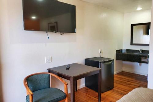 Habitación con mesa, lavabo y silla en Premier Inn & Suites en Oakland