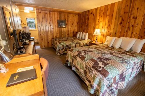 a hotel room with two beds and a television at Castle Mountain Lodge in Estes Park