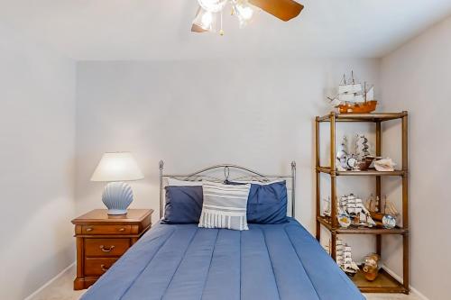 een slaapkamer met een blauw bed met een lamp en planken bij 3rd Avenue Oasis in Myrtle Beach