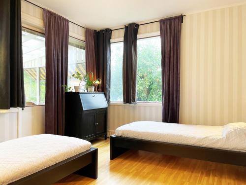 ベーナムーにあるWell-equipped holiday home in Varnamoのベッドルーム1室(ベッド2台、テレビ、窓付)