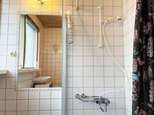 y baño con ducha, lavabo y espejo. en Well-equipped holiday home in Varnamo, en Värnamo