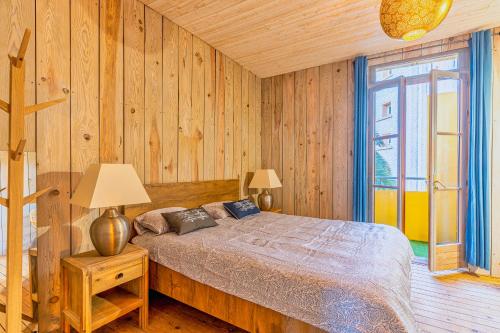 een slaapkamer met een bed en een houten muur bij La Maison des Huîtres in Arcachon