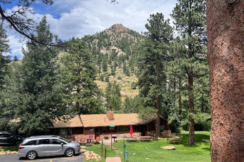 a car parked in front of a house with a mountain at Castle Mountain Lodge in Estes Park