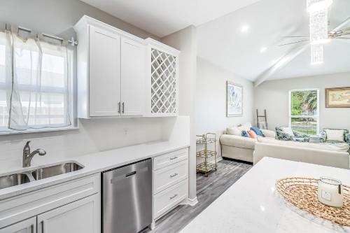 Una cocina con gabinetes blancos y una sala de estar. en Bay Breeze Beauty, en Padre Island