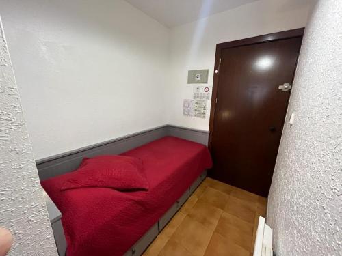 Habitación pequeña con cama roja en la esquina en Immodelpas Madriu, en Pas de la Casa