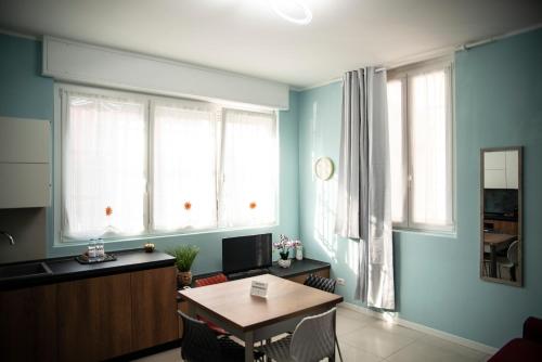 a living room with a table and two windows at Casa Fulvia in Rozzano