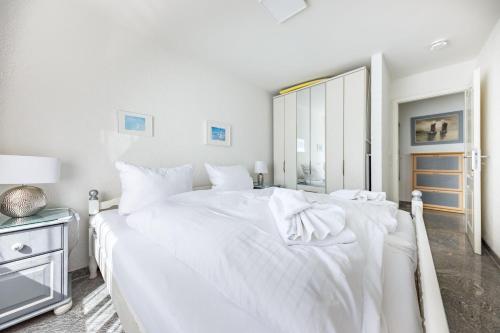 1 dormitorio blanco con 1 cama grande con sábanas blancas en Haus-Momoa-Duenenburg, en Westerland