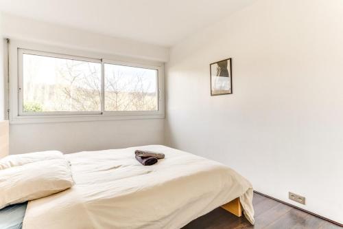 a white bedroom with a bed and a window at Bel Espace, Paris-saclay, Visite Famille Business in Gif-sur-Yvette