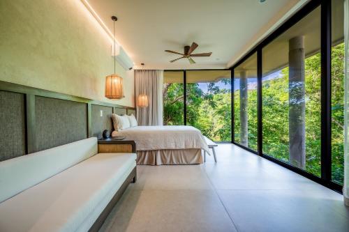 - une chambre avec un lit et une grande fenêtre dans l'établissement Jungle Sanctuary, à El Jobo