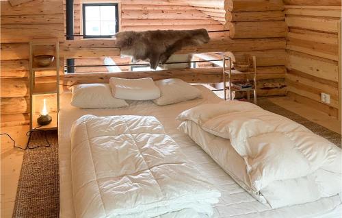 a bed in a log cabin with a cat jumping on it at Nice Home In Kittelfjll With House A Mountain View in Kittelfjäll