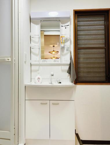 a white bathroom with a sink and a mirror at Tokyo Louis House in Ueno area close to JR Yamanote Line & Metro Ginza Line walk to Ueno Park and Ameyoko in Tokyo