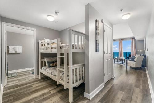 a room with two bunk beds and a living room at Shores of Panama #1921 by Nautical Properties in Panama City Beach