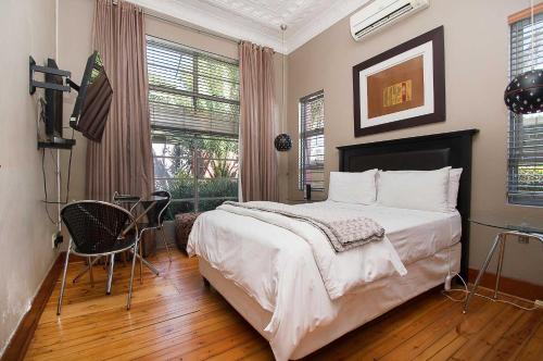 a bedroom with a bed and a television in it at Saffron Guest House in Johannesburg