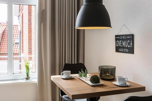 mesa de comedor con lámpara negra y ventana en Woge2 Appartement 10, en Borkum