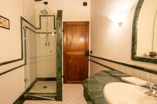 een badkamer met een wastafel, een douche en een spiegel bij Villa Belforte by VacaVilla in Lamporecchio