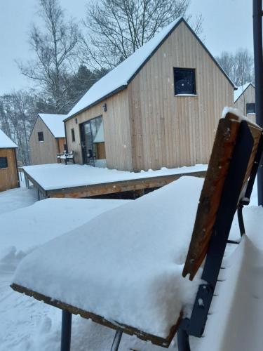 a bench covered in snow in front of a building at PRIMÁTOR CAMPING RESORT LITOMYŠL in Litomyšl