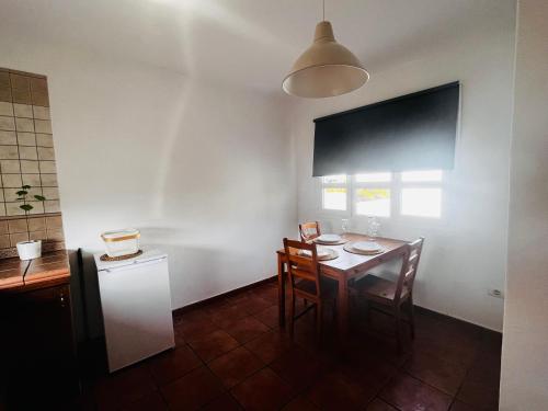 ein Esszimmer mit einem Tisch, Stühlen und einem Fenster in der Unterkunft Apartamento en el centro de Lanzarote in Tiagua