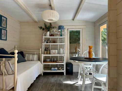 Schlafzimmer mit einem Bett und einem Tisch in der Unterkunft Driftwood Dreams Garden Cabin in Lyminster