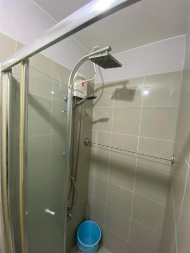 La salle de bains est pourvue d'une douche avec une porte en verre. dans l'établissement Grass residence tower2 29th, à Manille