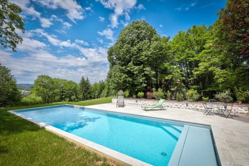 une piscine dans la cour d'une maison dans l'établissement gîte le Magnolia, à Thorens-Glières