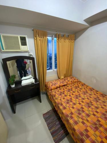 - une petite chambre avec un lit et un miroir dans l'établissement Grass residence tower2 29th, à Manille