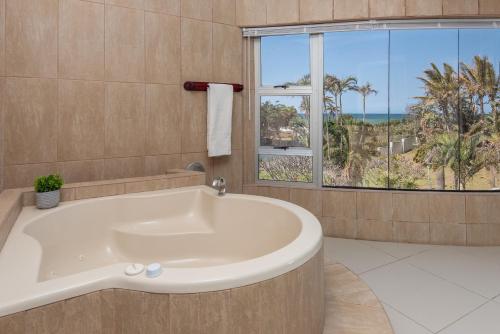 a bathroom with a tub and a large window at The Beach Palace Ramsgate in Margate