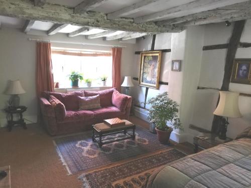 ein Wohnzimmer mit einem Sofa und einem Tisch in der Unterkunft Michaelmas Cottage Upavon in Upavon