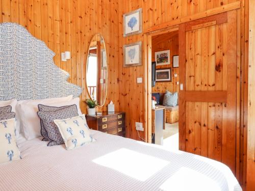 a bedroom with a white bed and a mirror at Kestrel in Seaton