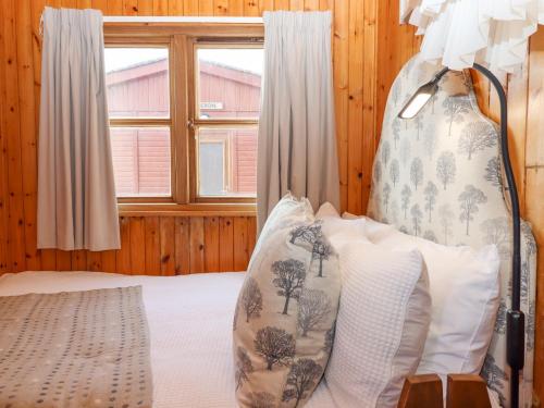 a bedroom with a bed and a window at Kestrel in Seaton