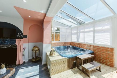 un bagno con ampia vasca e finestra di Big House with En-suites a Big garden and Hot-tub near TOWER BRIDGE a Londra