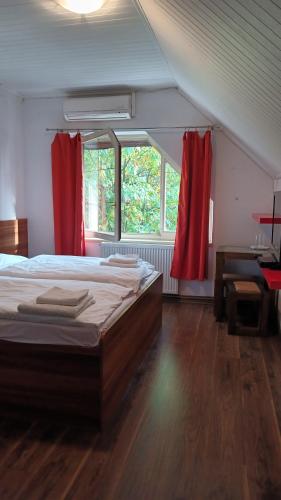 a bedroom with a bed with red curtains and a desk at Ardilla in Lhota