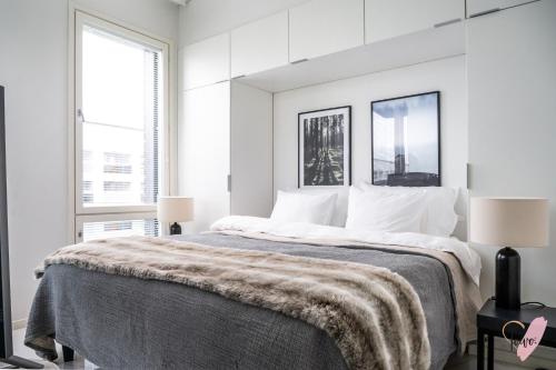 biała sypialnia z dużym łóżkiem i 2 oknami w obiekcie Elegant apartment in Oulu w mieście Oulu