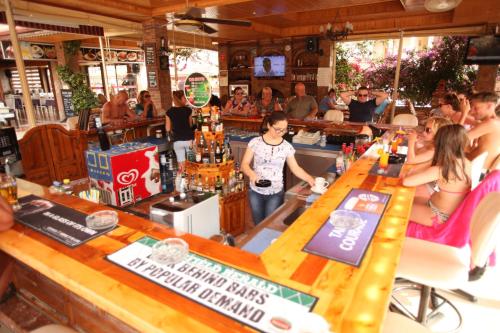 a group of people sitting at a bar at Turk Hotel in Oludeniz