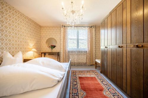 een slaapkamer met een groot bed en een kroonluchter bij 7202 Zweckmaessig eingerichteten Wohnung mit gedecktem Balkon in Vulpera