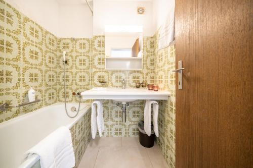 een badkamer met een bad, een wastafel en een bad bij 7202 Zweckmaessig eingerichteten Wohnung mit gedecktem Balkon in Vulpera