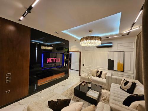 a living room with a tv and a couch and a fireplace at New Cairo's Poolside Oasis in New cairo