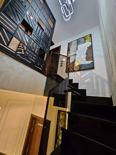 a lobby with black stairs and a screen on the wall at New Cairo's Poolside Oasis in New cairo