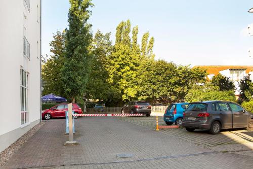 a parking lot with cars parked next to a building at Hotel Kronprinz in Greifswald