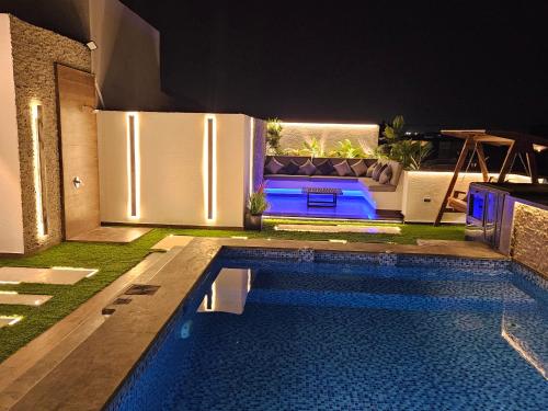 a swimming pool in a backyard with a couch and a table at New Cairo's Poolside Oasis in New cairo