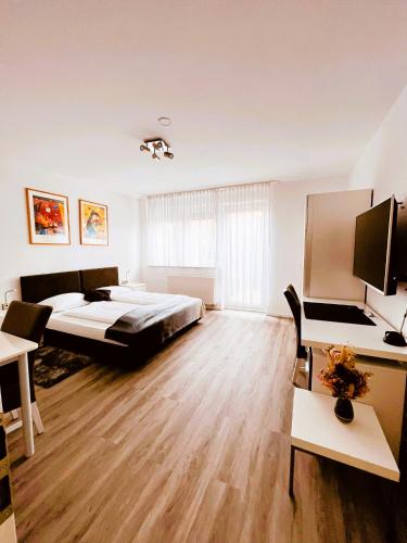a bedroom with a bed and a desk with a computer at Schubart Apartments in Bietigheim-Bissingen