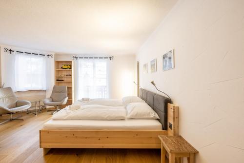 a bedroom with a wooden bed in a room at 7304 Pure Freude in dieser stilvoll renovierten Wohnung mit moderner Kueche in Vulpera