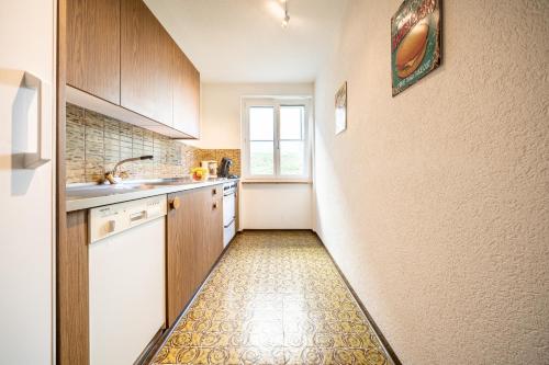 a small kitchen with wooden cabinets and a window at 8001 Gemuetliche 2,5-Zimmer-Wohnung mit wunderschoenem Ausblick Richtung Scuol in Vulpera
