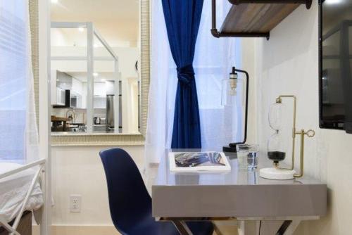 紐約的住宿－75-A New stylish Loft 1BR W D Prime Upper east，靠窗边的一张桌子和一张蓝色的椅子