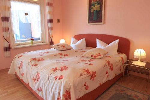 ザスニッツにあるFerienwohnung Panoramablickのベッドルーム1室(赤い花のベッド1台付)