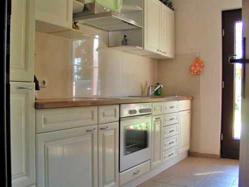 a kitchen with white cabinets and a stove at Apartment Tina in Ahrenshagen